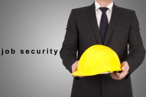 Business professional presenting a safety helmet, representing trust, stability, and job security.